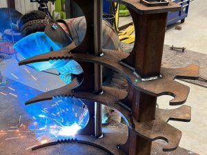 Welding some farming equipment, sparks flying.
